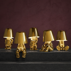 Five gold thinker table lamps arranged on dark basalt steps