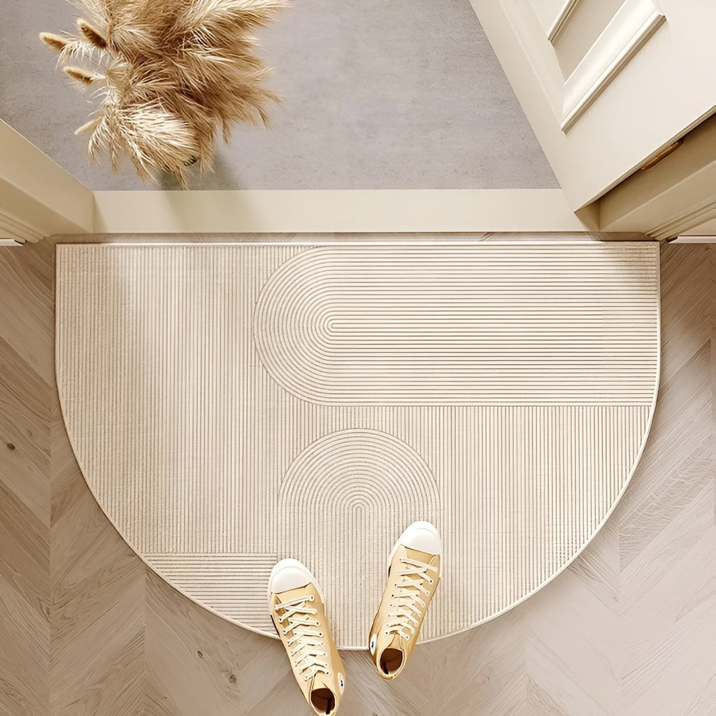 Beige semicircle door mat with fine curved line pattern at an entry.