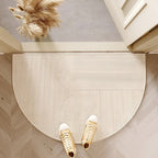 Beige semicircle door mat with fine curved line pattern at an entry.