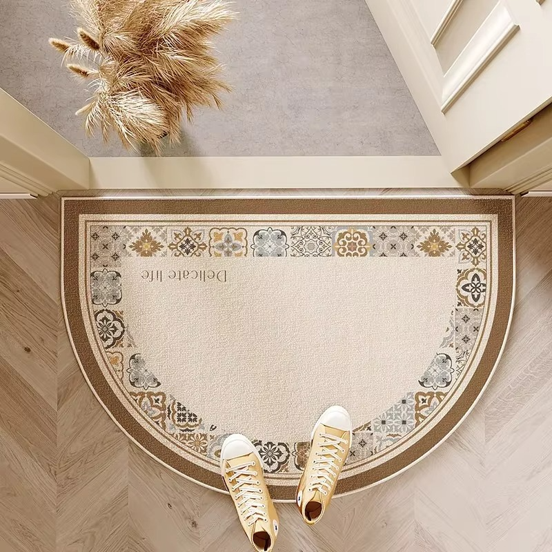Patterned semicircle door mat with decorative border and lettering.