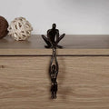 Black two figure resin sculpture displayed on a wooden shelf edge