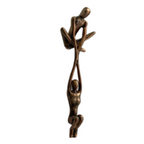 Bronze shelf edge sculpture with two linked figures on a white background