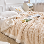 Cream white jacquard sherpa throw blanket spread across a bed