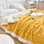 Yellow jacquard sherpa throw blanket spread across a bed