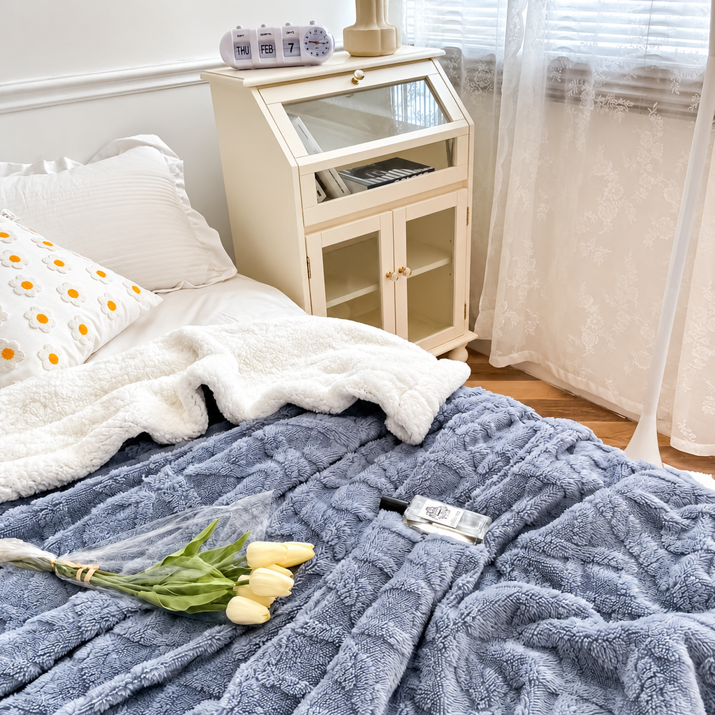 Blue jacquard sherpa throw blanket spread across a bed
