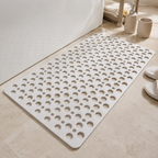 Non slip shower mat in white laid flat beside a white bathtub