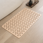 Non slip shower mat in beige laid flat beside a white bathtub