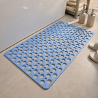 Non slip shower mat in blue laid flat beside a white bathtub
