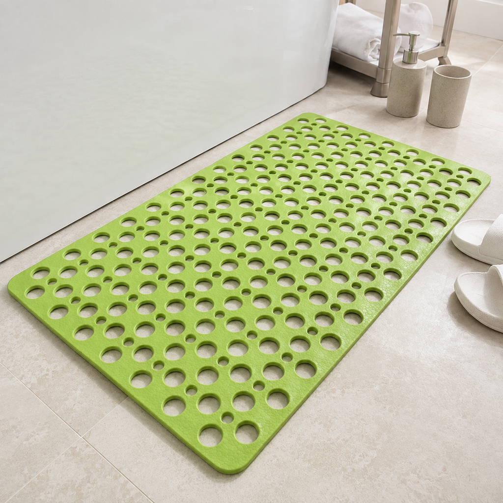 Non slip shower mat in green laid flat beside a white bathtub