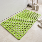 Non slip shower mat in green laid flat beside a white bathtub