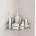 Shower shelf in silver aluminum with one corner tier holding pale toiletries