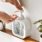 White soap dispenser delivering liquid into an open hand.
