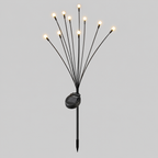 Solar-powered fiber optic garden lights with multiple thin black stems emitting warm white light bulbs, featuring a small black solar panel and stake, shown against a solid gray background.