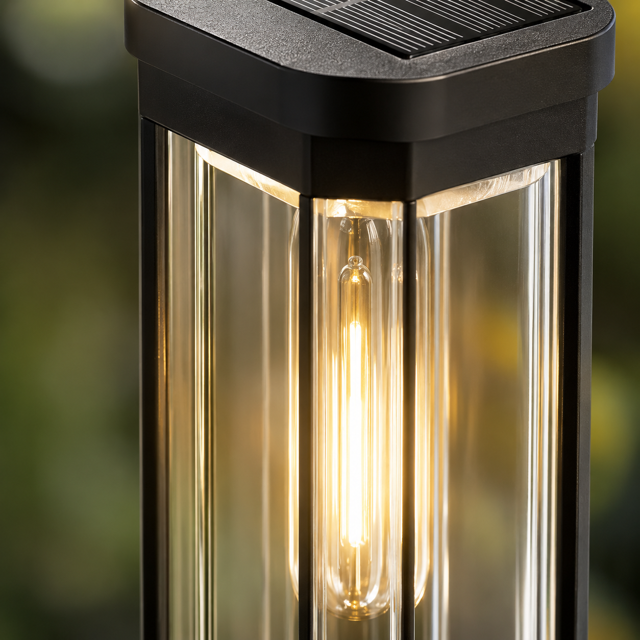 Close-up of the black solar pathway light showing the textured solar panel, clear lantern panels, and glowing filament-style LED.