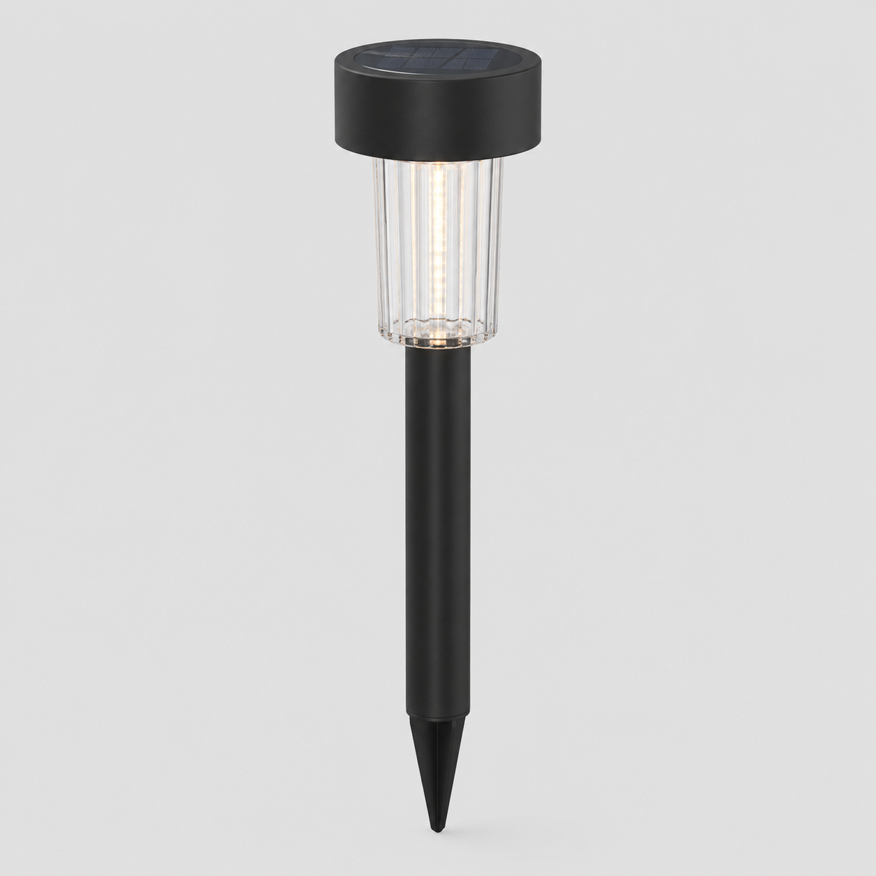 A solar-powered ground stake light with a black top cap, clear ribbed glass shade, and black stake, shown against a light gray background.