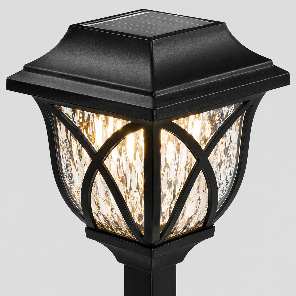 A black solar-powered outdoor post cap light with a warm glowing seeded glass shade, shown against a solid gray background.