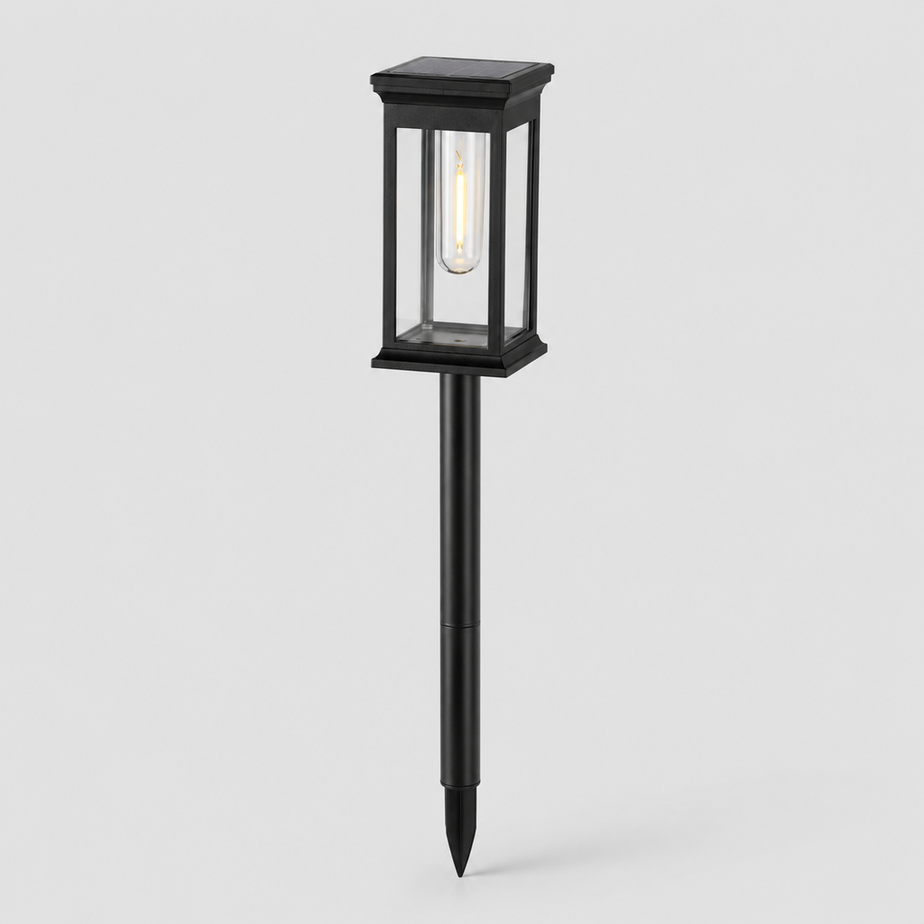 A black solar-powered outdoor landscape light with a rectangular glass lantern-style shade and a stake base, shown against a light gray background.