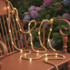 Solar rope lights drape over a terracotta metal chair with hydrangeas behind.
