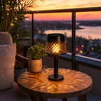 Four black solar-powered table lanterns on a garden patio table beside potted succulents
