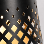 Close-up of solar table lamp with hollowed-out metal shade and warm white light