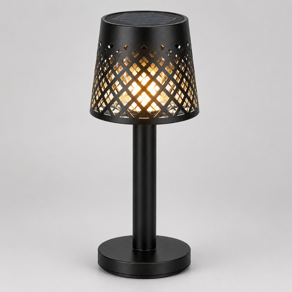 A black table lamp with a cylindrical base and a perforated shade that glows with warm light, shown on a neutral gray background.