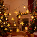 Star and globe string lights hanging beside a decorated Christmas tree.