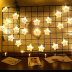 Star fairy lights hanging across a wire grid above a desk.