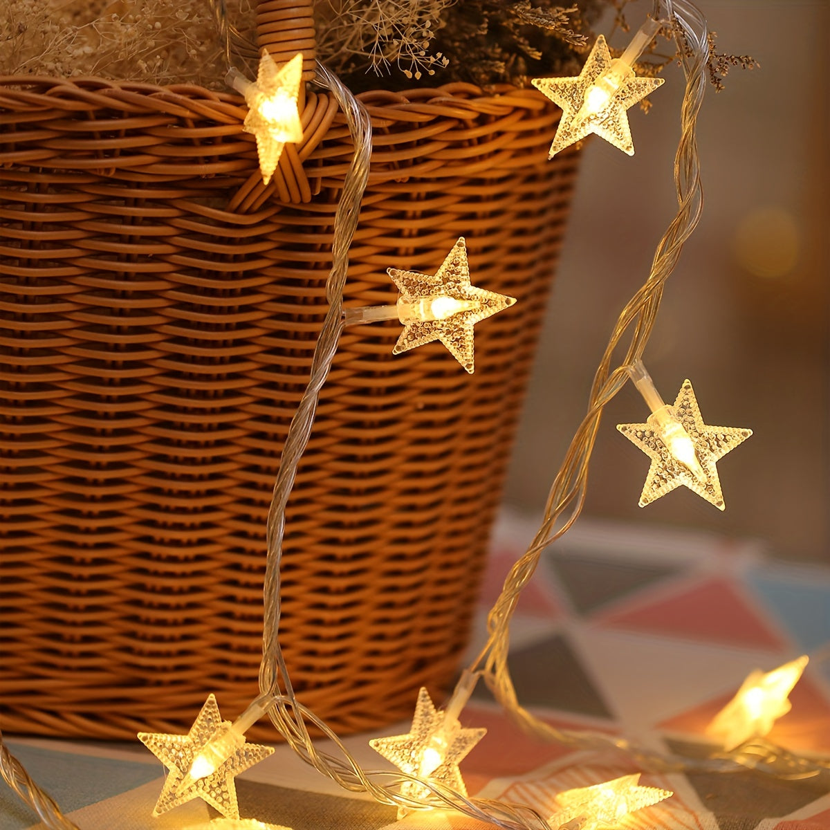 Star fairy lights glow in a close view beside a wicker basket.