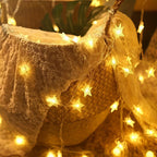 Warm white star lights draped around a fabric display
