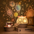 Star projector night light casting celestial patterns beside its packaging