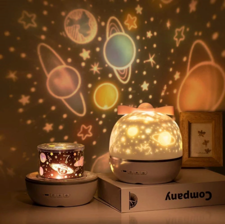 Star projector night light casting celestial patterns beside its packaging