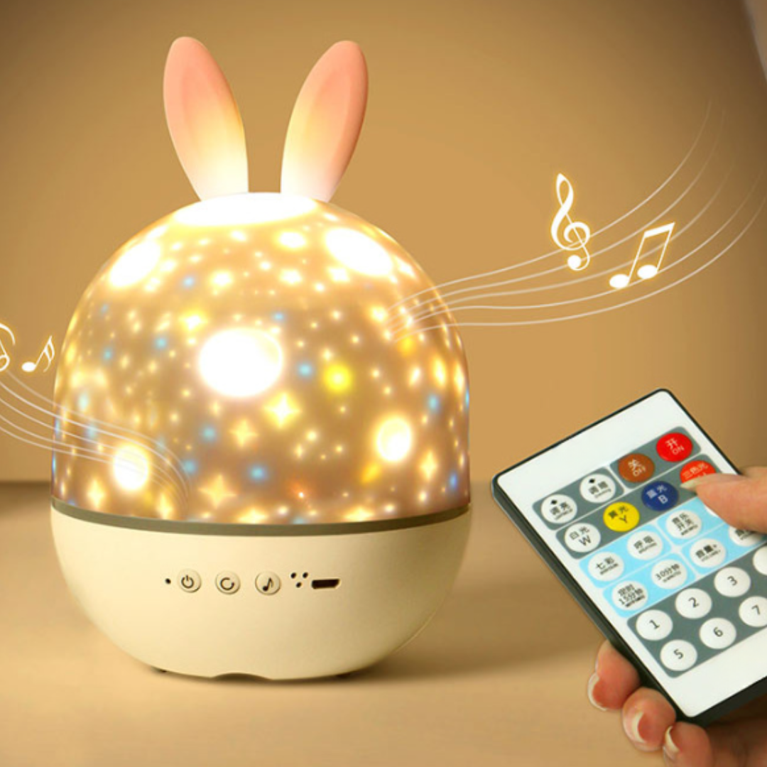 Star projector night light with rabbit ears beside a remote control
