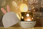 Star projector night light with its dome removed beside a projected scene