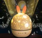 Star projector night light surrounded by projected stars and music graphics