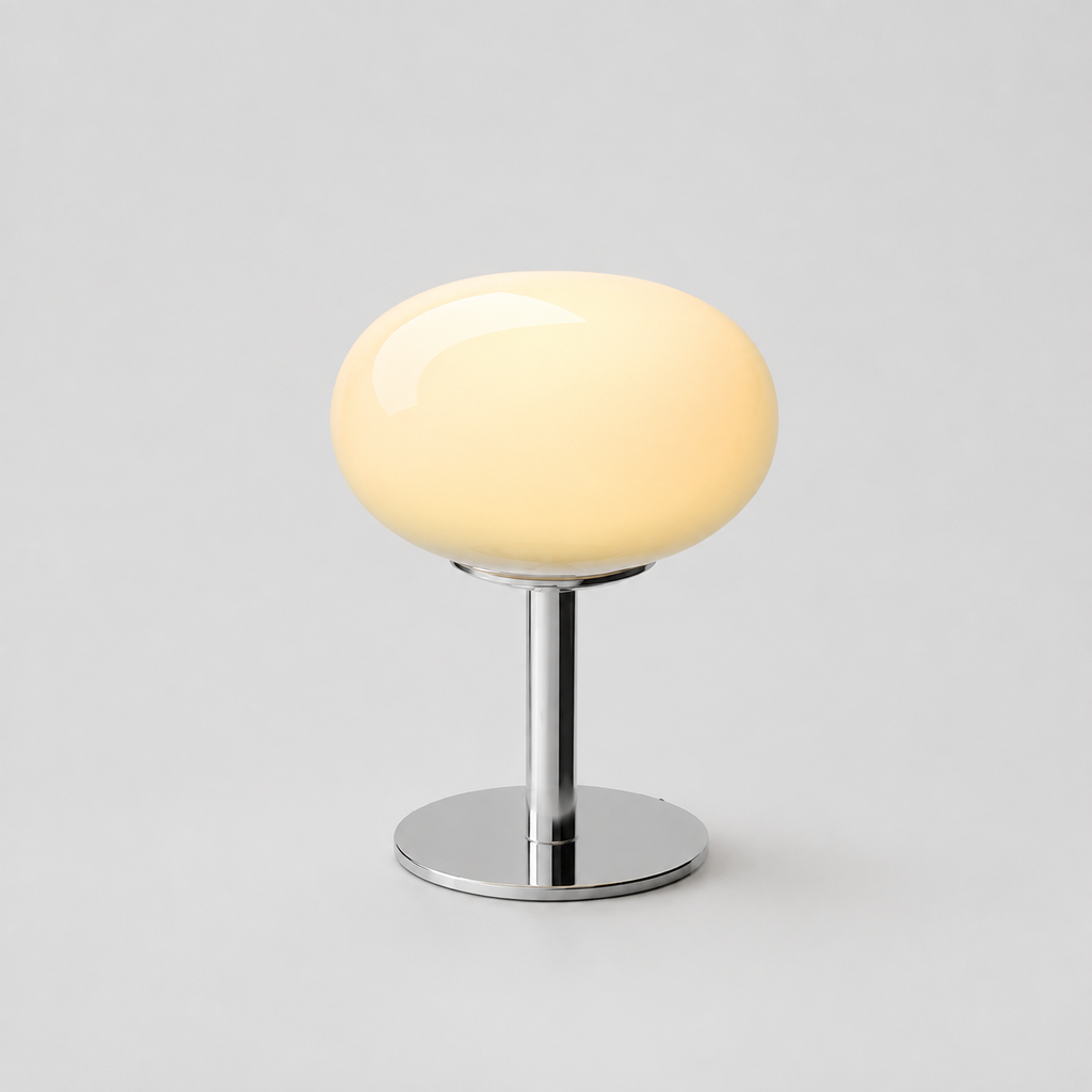 Pale yellow oval glass table lamp isolated on a cool gray background.