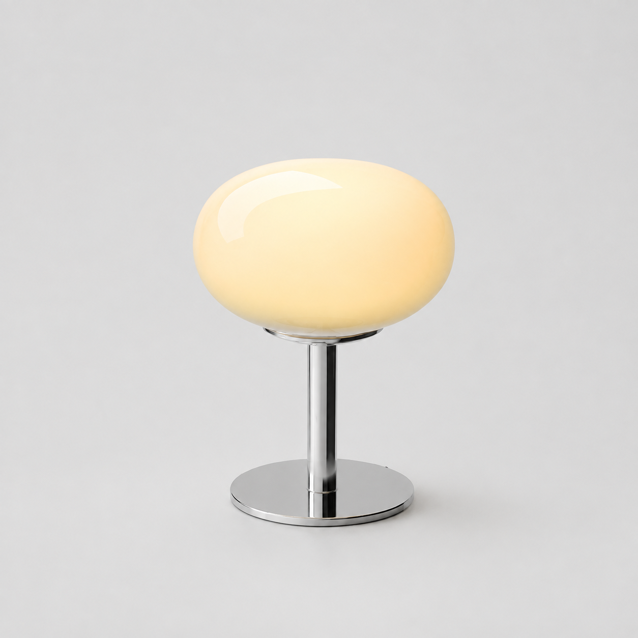 Pale yellow oval glass table lamp isolated on a cool gray background.