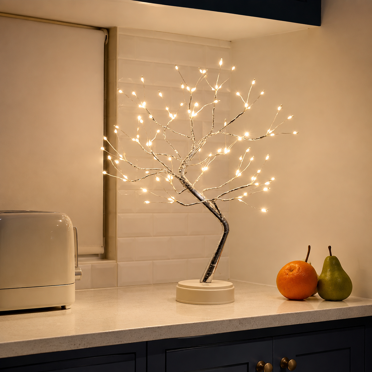 Tree of Light table lamp lit on a white kitchen counter beside fruit.