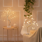 Two Tree of Light table lamps glowing in a peach bedroom.