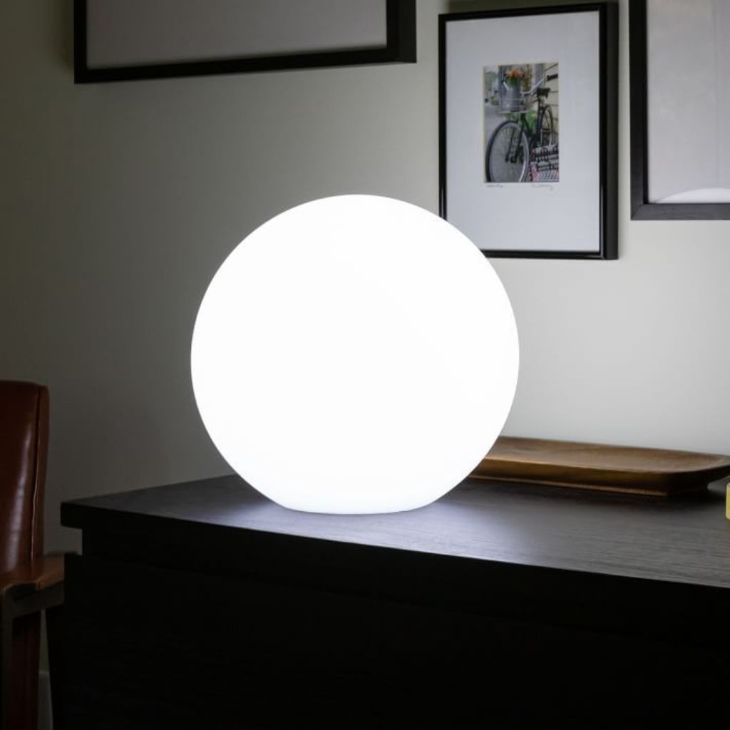 LED moon lamp illuminating an evening setting.