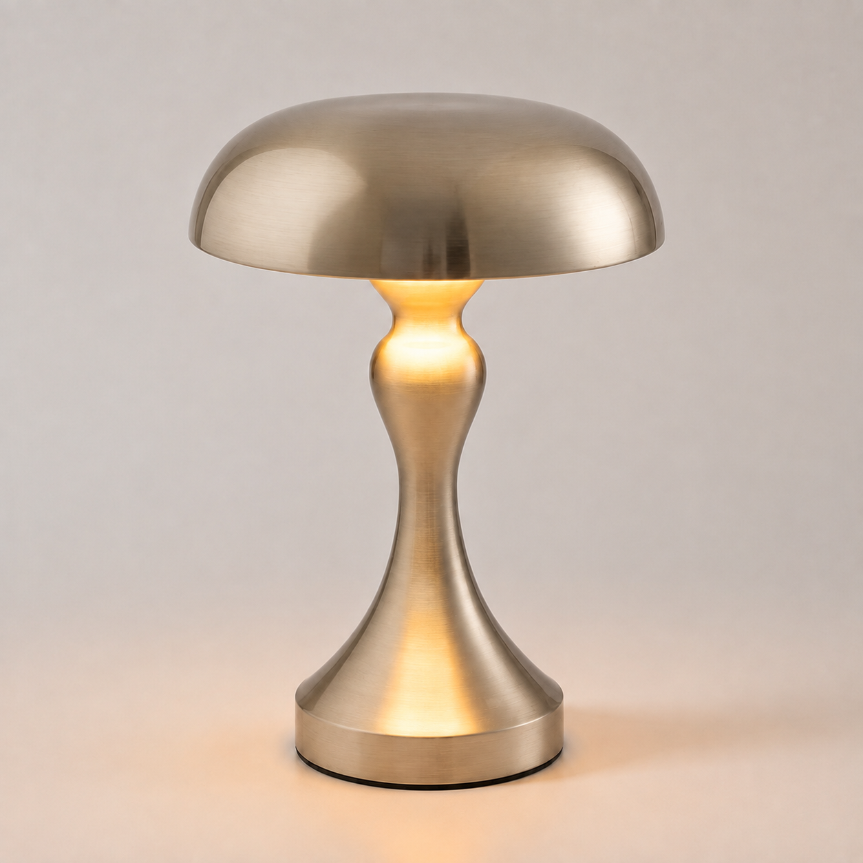 Silver table lamp glowing against a light gray background.
