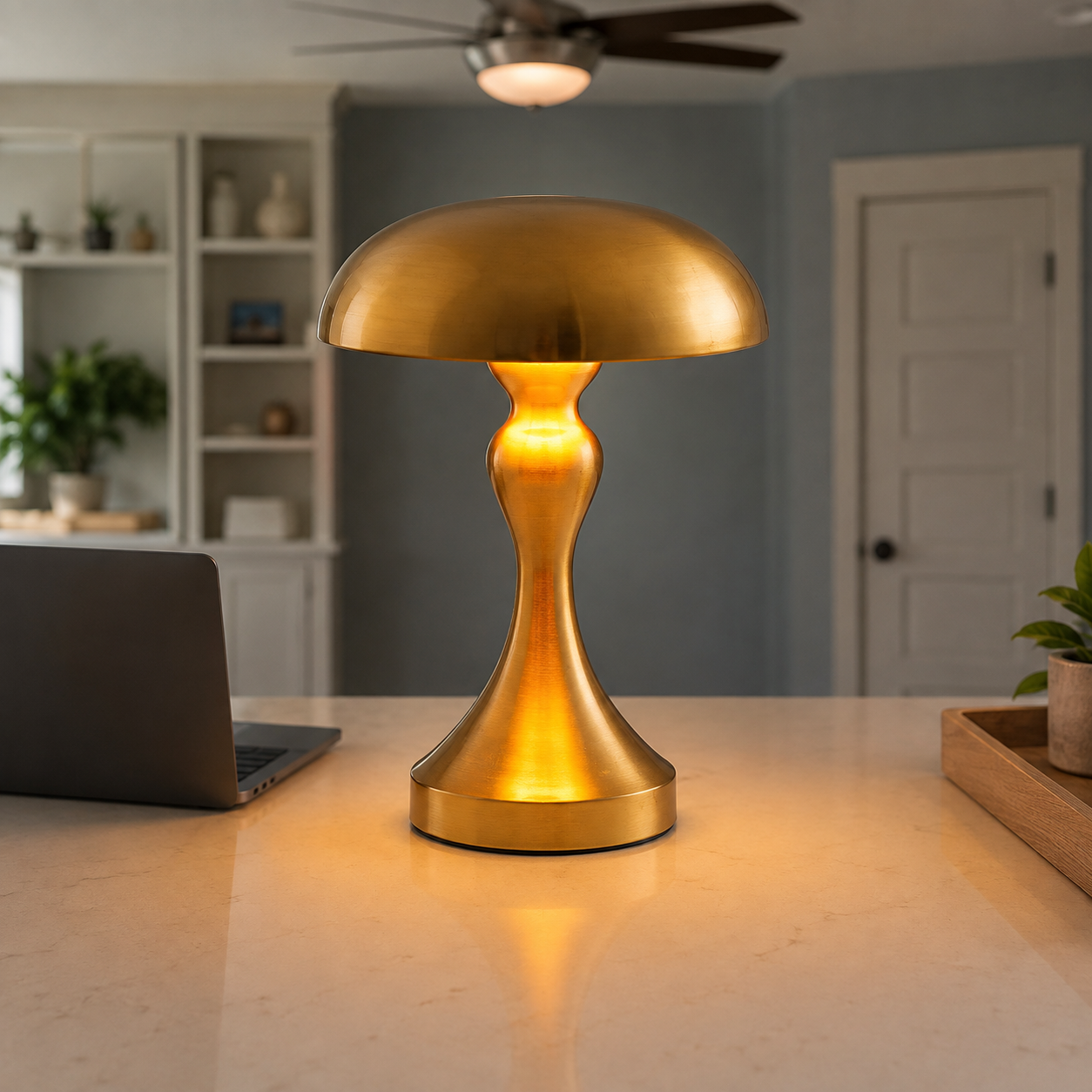 Gold table lamp glowing on a kitchen counter in a bright open interior.
