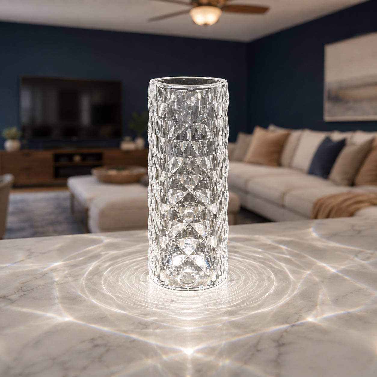 Clear faceted table lamp glowing on white bedding in a dark bedroom setting.
