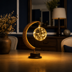 Crescent moon table lamp lit on a console in a dark living room.