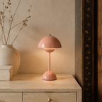 pink dome table lamp glowing beside a plain ceramic vase