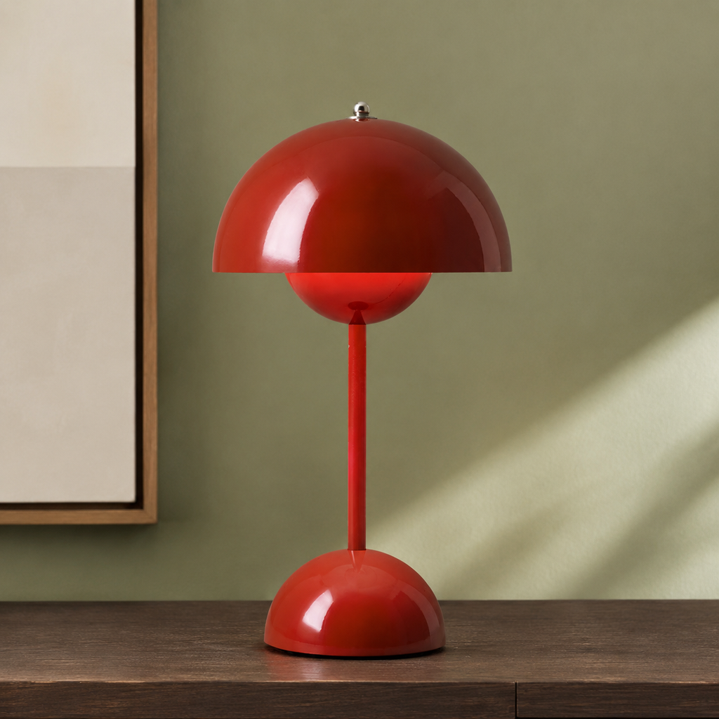 red dome table lamp on a wood console against a sage wall