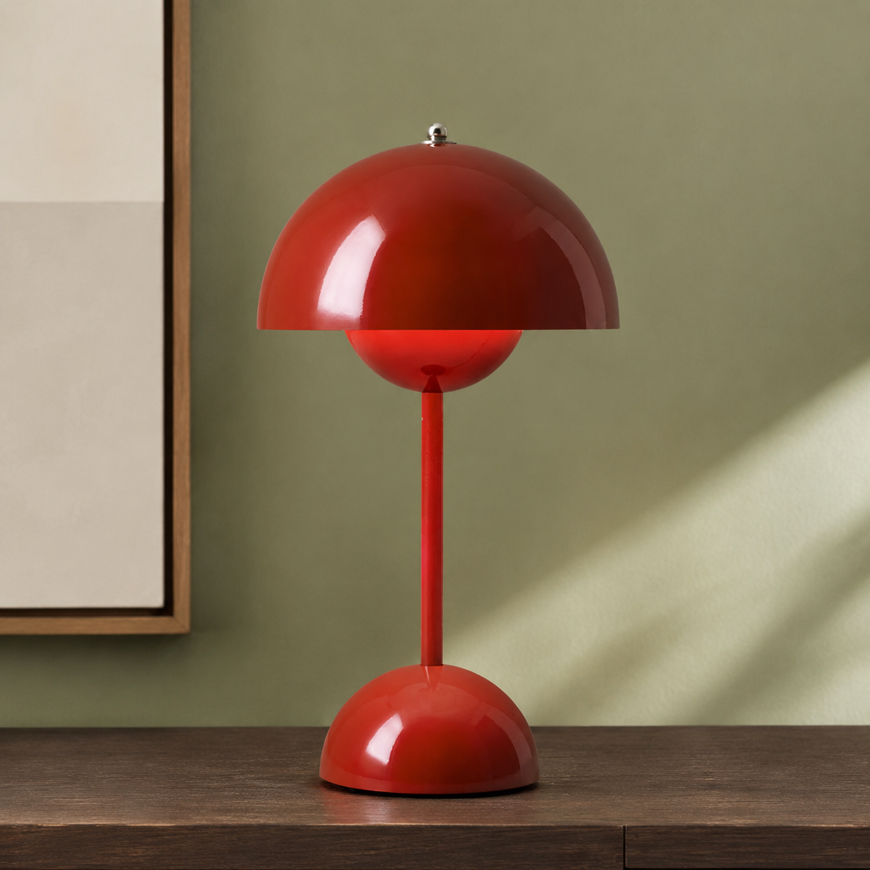 red dome table lamp on a wood console against a sage wall