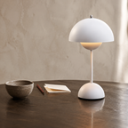 white dome table lamp glowing on a dark wood table