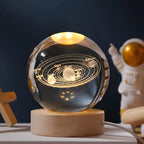 Crystal sphere table lamp with solar system engraving on a wooden light base