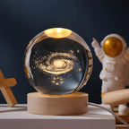Crystal sphere table lamp with galaxy engraving on a wooden light base