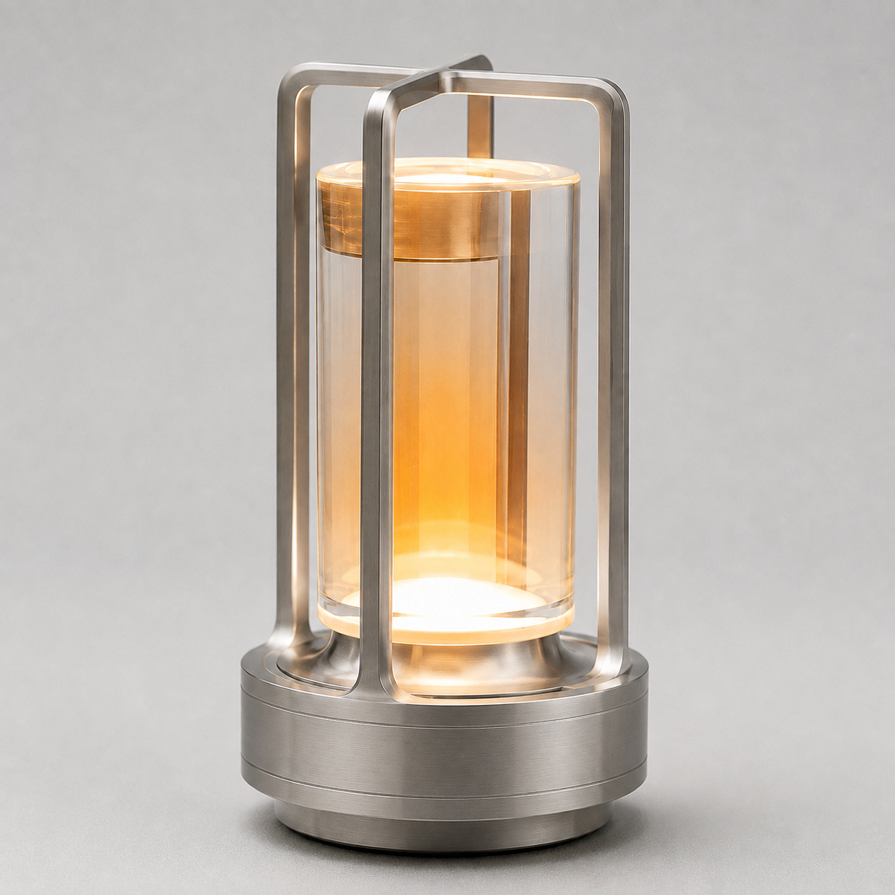 Silver cordless lantern table lamp with a clear cylindrical shade, illuminated against a neutral background.